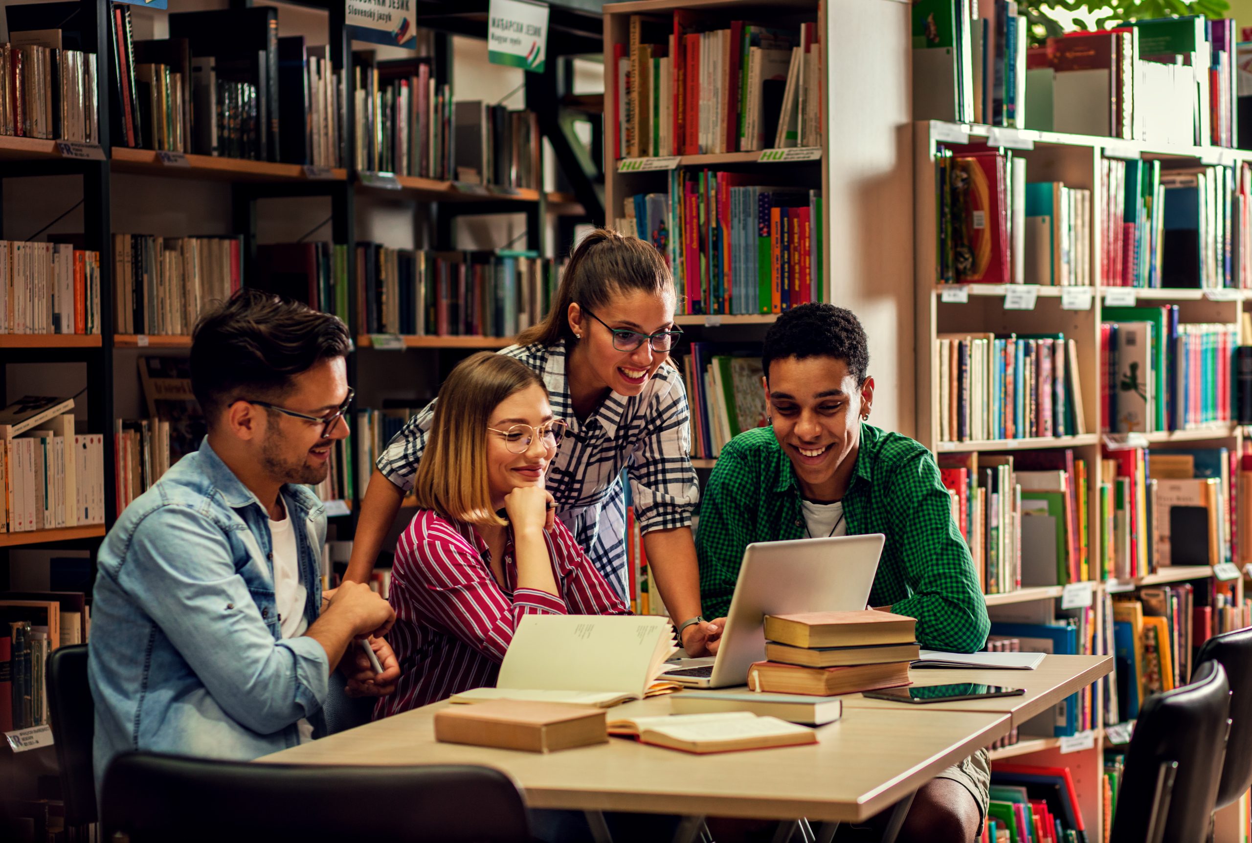 Four young students study in the school library, female student